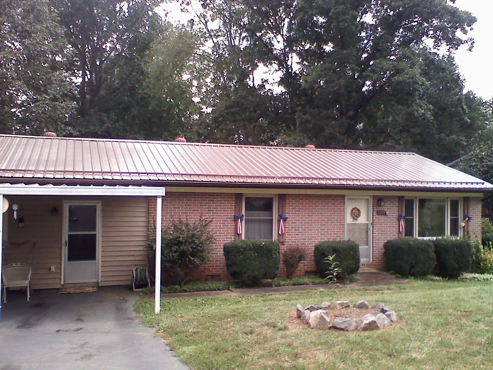 Bronze metal roof and carport on a brick ranch home — Roof Repair work by our crew in Hollister